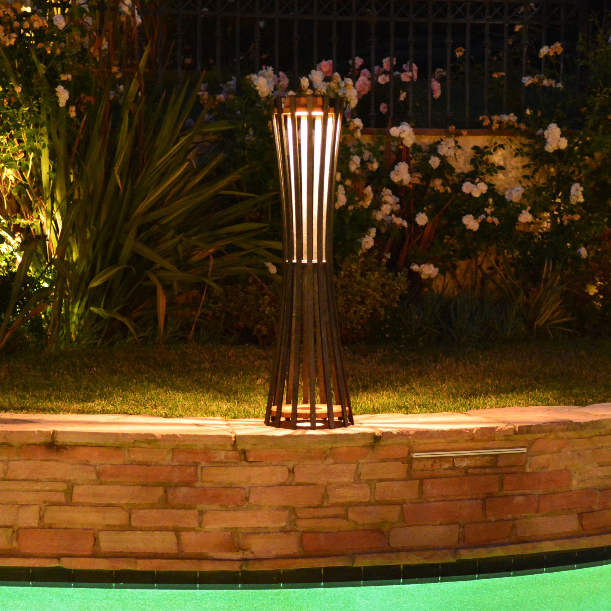 photo of corsetta solar lamp lighting outdoor garden and pool surrounding flowers and plants