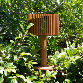Pixy table light teak outdoor in fence surrounded by plants