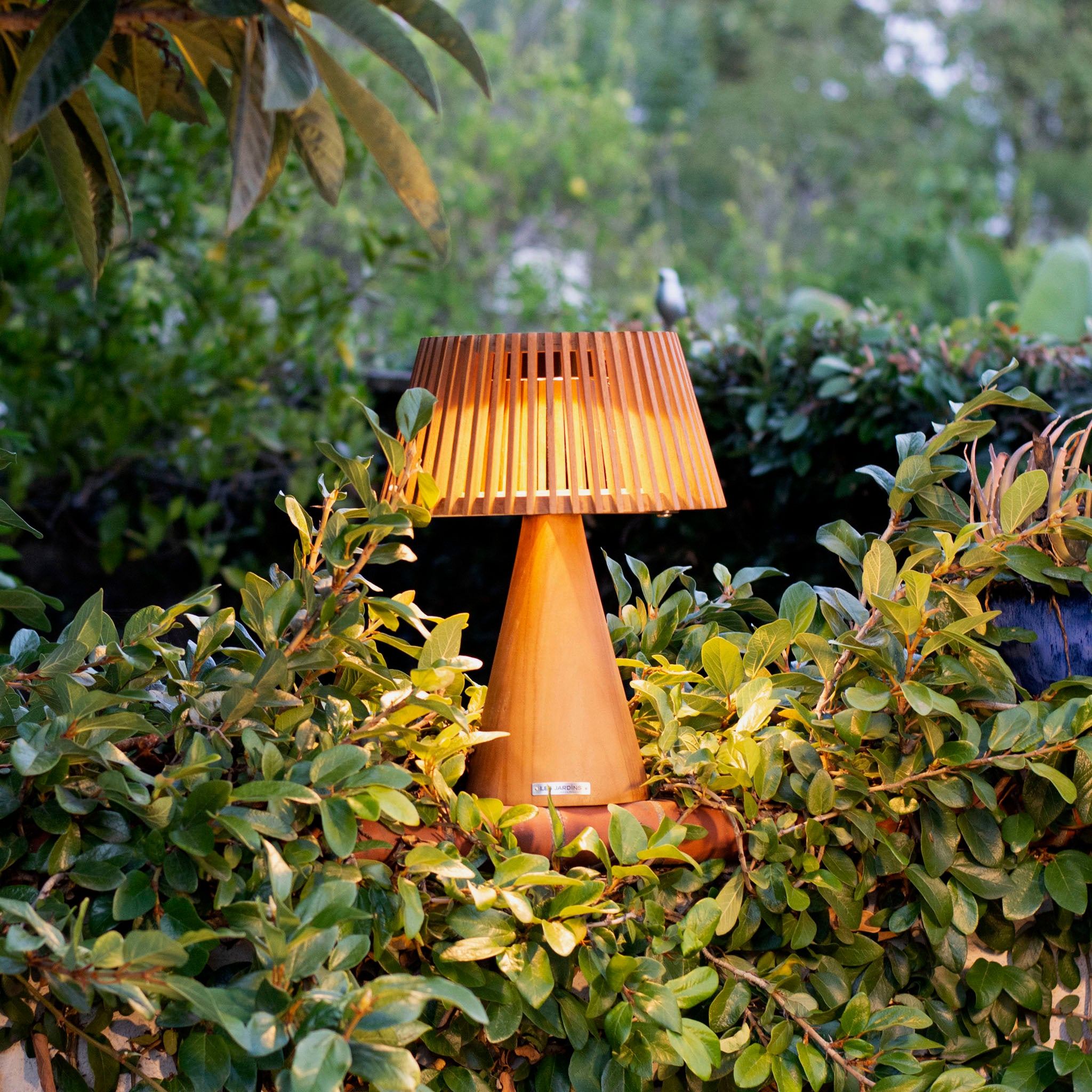 enoki table lamp on fence lighting up surrounding plants